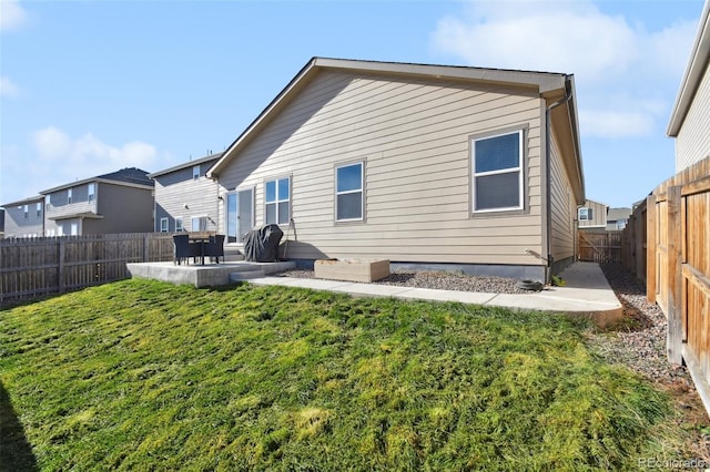 rear view of property featuring a lawn and a patio area