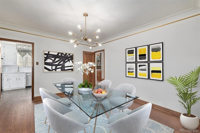 dining space featuring crown molding, dark hardwood / wood-style floors, a chandelier, and sink