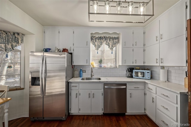 kitchen with sink, tasteful backsplash, appliances with stainless steel finishes, dark hardwood / wood-style floors, and white cabinets