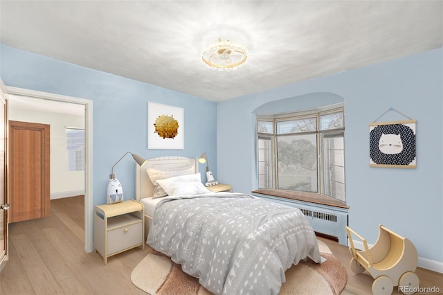 bedroom with radiator and light wood-type flooring