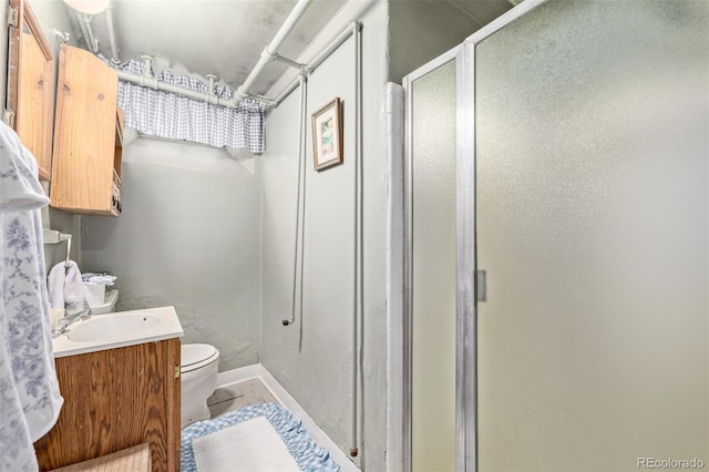 bathroom featuring vanity, toilet, and walk in shower