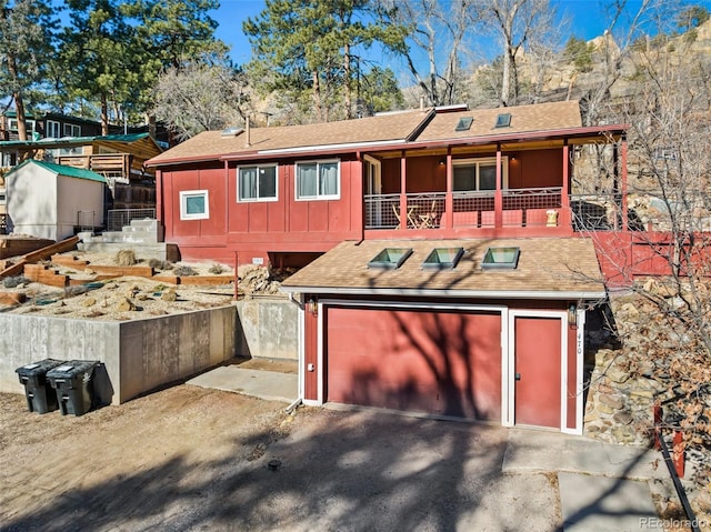 470 Bear Creek Rd, Colorado Springs, CO 80906 - rear view of house featuring board and batten siding, roof with shingles, asphalt driveway, and an attached garage