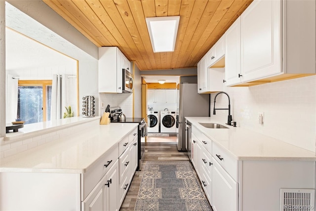 470 Bear Creek Rd, Colorado Springs, CO 80906 - kitchen featuring appliances with stainless steel finishes, washing machine and dryer, wooden ceiling, a sink, and backsplash