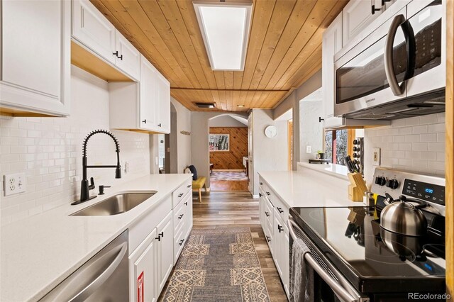 470 Bear Creek Rd, Colorado Springs, CO 80906 - kitchen with appliances with stainless steel finishes, a sink, dark wood-style floors, wood ceiling, and light countertops