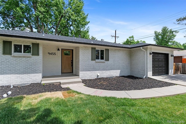 9455 W 37th Ave, Wheat Ridge, CO 80033 - ranch-style house with an attached garage, brick siding, driveway, and a front yard