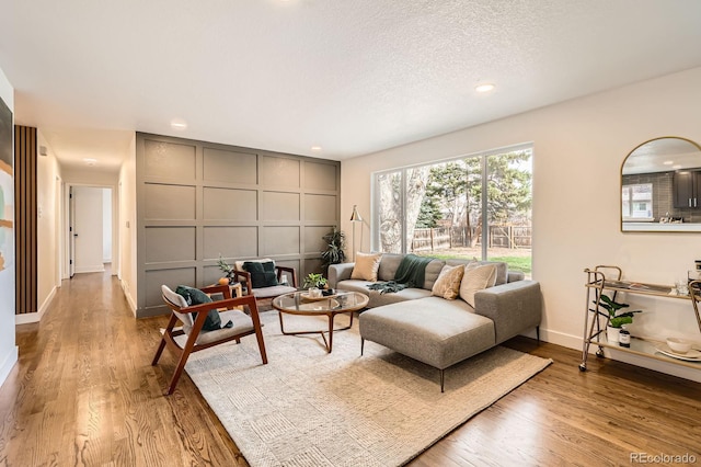 9455 W 37th Ave, Wheat Ridge, CO 80033 - living room featuring wood finished floors, recessed lighting, baseboards, a decorative wall, and a textured ceiling