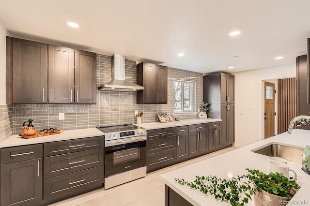 9455 W 37th Ave, Wheat Ridge, CO 80033 - kitchen with wall chimney range hood, electric stove, backsplash, a sink, and light countertops