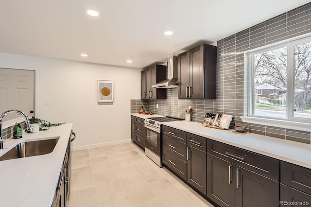 9455 W 37th Ave, Wheat Ridge, CO 80033 - kitchen featuring wall chimney exhaust hood, a sink, stainless steel electric stove, baseboards, and light countertops
