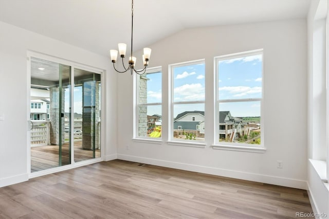 8346 Cokedale Cir, Littleton, CO 80125 - unfurnished dining area with plenty of natural light, a chandelier, wood finished floors, and vaulted ceiling