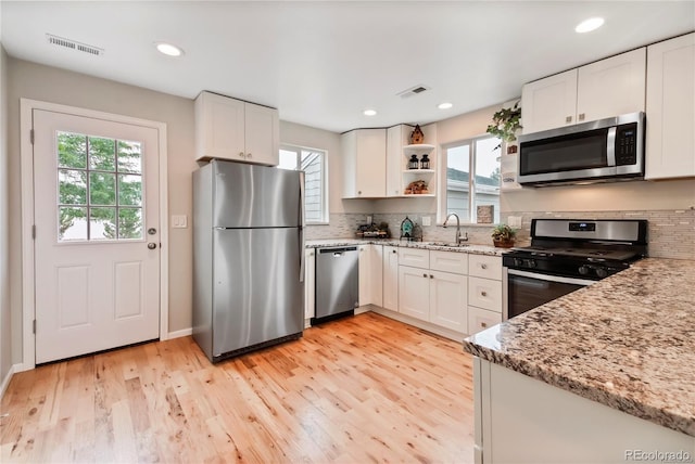 6245 W 53rd Ave, Arvada, CO 80002 - kitchen with stainless steel appliances, plenty of natural light, a sink, light stone countertops, and recessed lighting