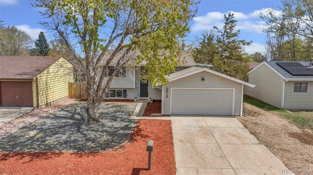 3516 Marigold St, Evans, CO 80620 - split level home featuring concrete driveway, fence, and a garage
