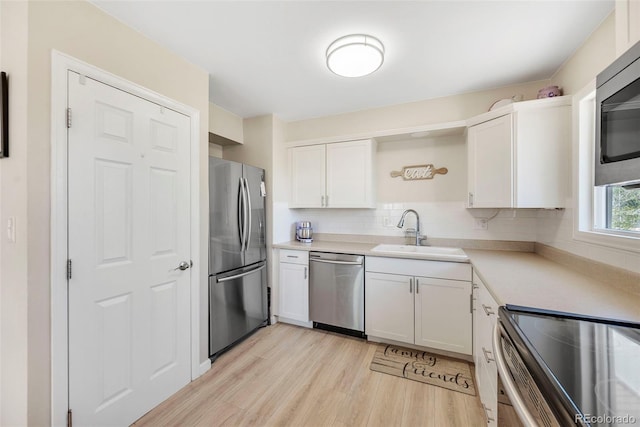 3516 Marigold St, Evans, CO 80620 - kitchen with appliances with stainless steel finishes, light wood-type flooring, a sink, light countertops, and white cabinetry