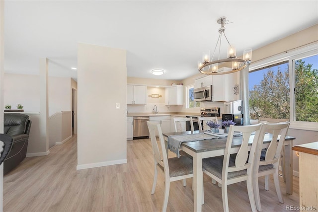3516 Marigold St, Evans, CO 80620 - dining room featuring light wood-style floors, baseboards, and a chandelier