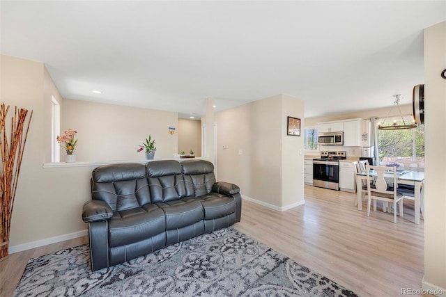 3516 Marigold St, Evans, CO 80620 - living room featuring baseboards, recessed lighting, and light wood finished floors
