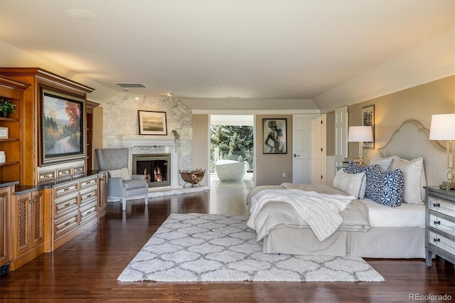 bedroom featuring dark hardwood / wood-style flooring and a fireplace