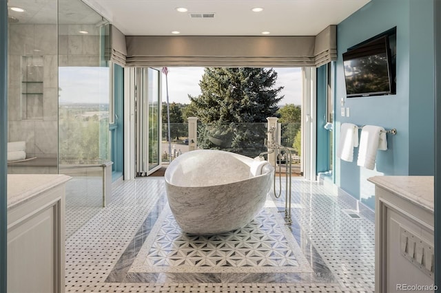 bathroom with tile patterned flooring, a bathing tub, and vanity