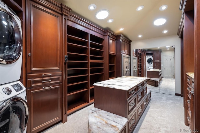 walk in closet featuring stacked washer / drying machine and light colored carpet