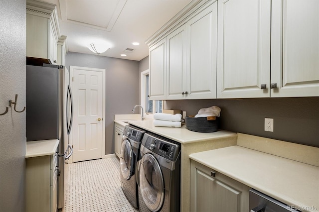 laundry room with cabinets, washing machine and dryer, and sink