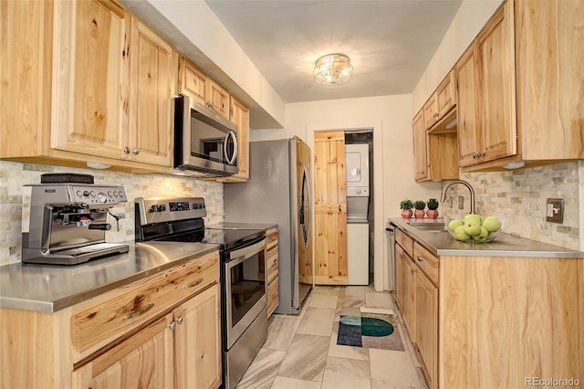 kitchen featuring decorative backsplash, appliances with stainless steel finishes, light brown cabinetry, sink, and stacked washer and clothes dryer