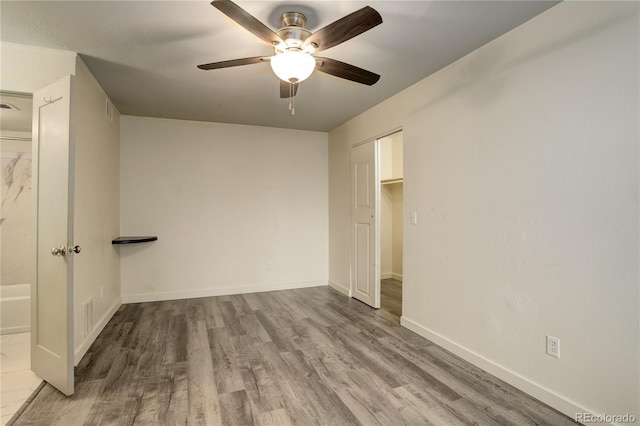 unfurnished bedroom with a ceiling fan, visible vents, baseboards, and wood finished floors