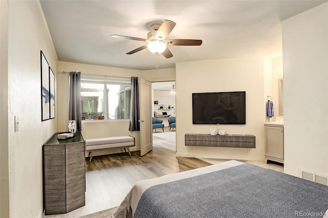 bedroom with light wood-style floors, visible vents, and a ceiling fan