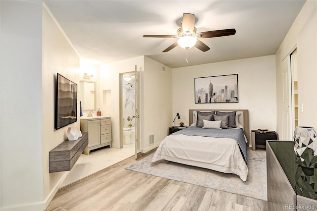 bedroom with visible vents, ensuite bathroom, ceiling fan, light wood-type flooring, and baseboards