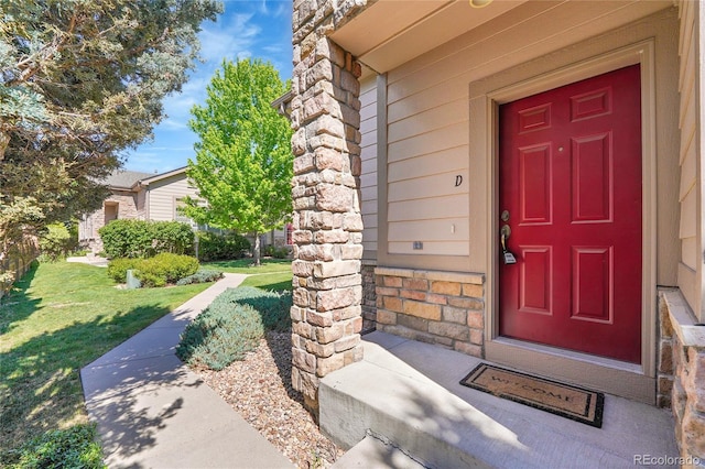 14333 E Napa Pl Unit 5D, Aurora, CO 80014 - doorway to property featuring stone siding and a lawn