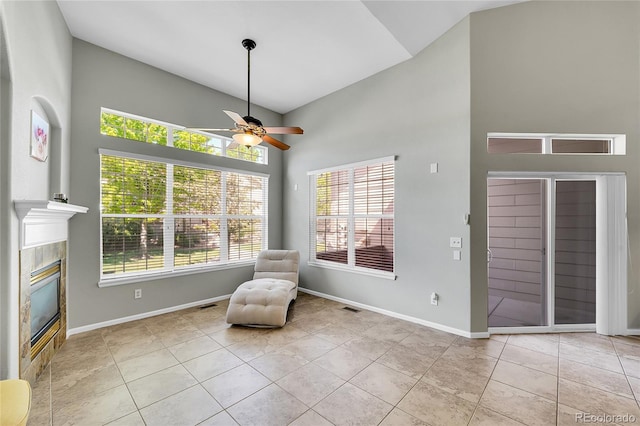 14333 E Napa Pl Unit 5D, Aurora, CO 80014 - sitting room featuring high vaulted ceiling, a ceiling fan, healthy amount of natural light, a tiled fireplace, and light tile patterned flooring