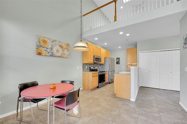 14333 E Napa Pl Unit 5D, Aurora, CO 80014 - kitchen featuring appliances with stainless steel finishes, light countertops, light brown cabinets, decorative backsplash, and baseboards