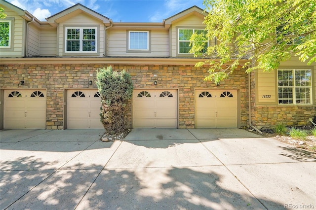 14333 E Napa Pl Unit 5D, Aurora, CO 80014 - view of front of property with stone siding, an attached garage, and driveway
