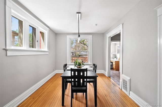 dining area with light wood-type flooring and baseboards