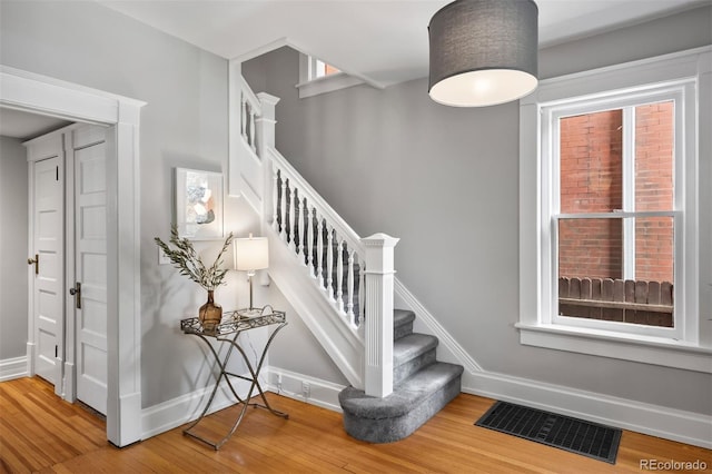 stairway with wood finished floors and baseboards