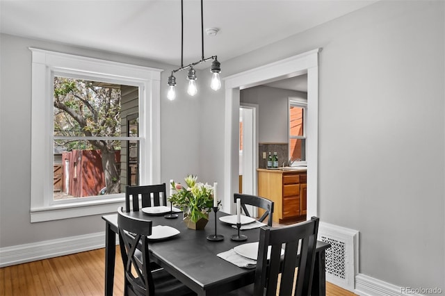 dining room featuring light wood-type flooring and baseboards