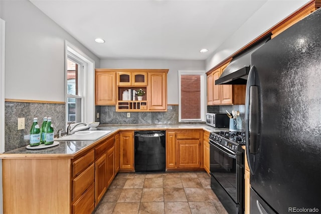 kitchen with black appliances, a sink, decorative backsplash, wall chimney exhaust hood, and open shelves