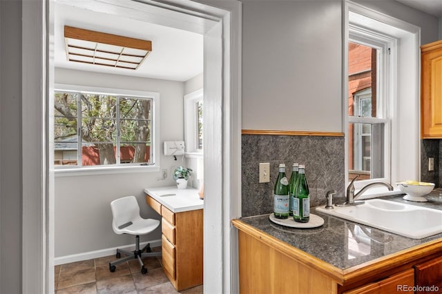 bathroom with baseboards, decorative backsplash, and vanity
