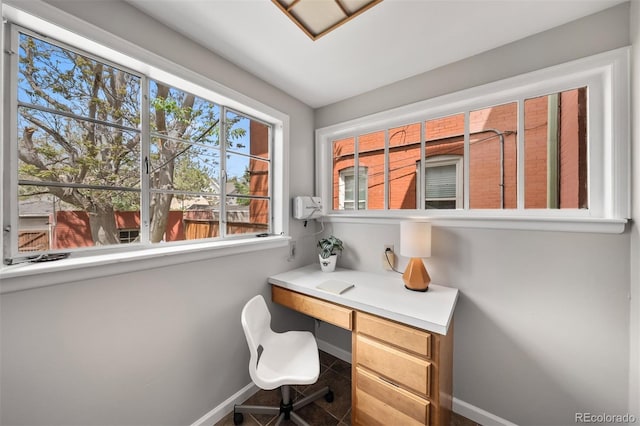 tiled office space featuring baseboards and built in desk