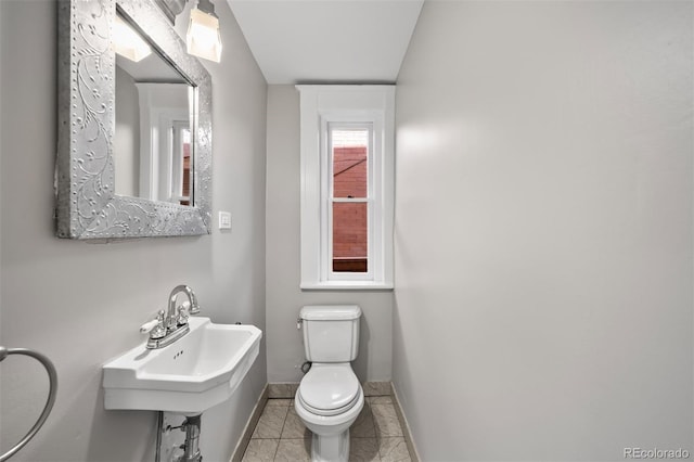 bathroom featuring toilet, baseboards, and tile patterned floors