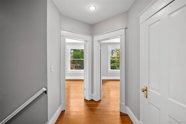 hallway featuring an upstairs landing, wood finished floors, baseboards, and recessed lighting