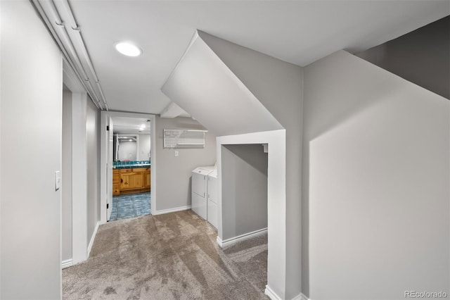 hallway with washer and dryer, carpet flooring, and baseboards
