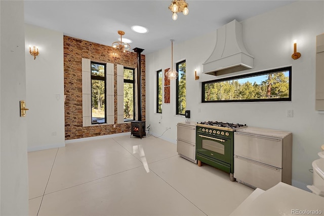 148 Ridge Ln, Bailey, CO 80421 - kitchen featuring custom exhaust hood, high end black range, a wood stove, concrete floors, and light countertops