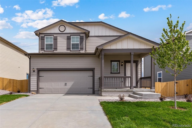 view of front facade with covered porch, fence, driveway, a garage, and a front yard