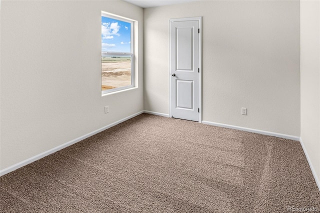 spare room with carpet and baseboards