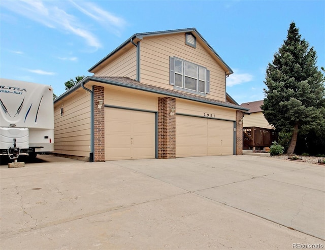 traditional-style house featuring brick siding, concrete driveway, and an attached garage