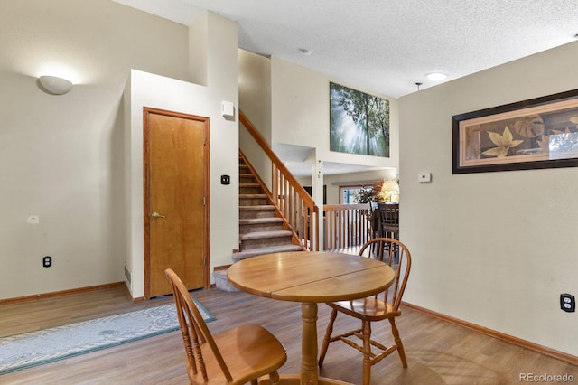 dining space featuring stairway, baseboards, and light wood-style flooring