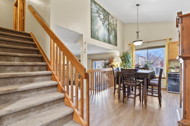 dining room with stairway, a textured ceiling, and light wood-style floors