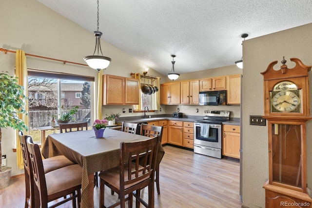 kitchen featuring lofted ceiling, electric range, light wood-style floors, black microwave, and pendant lighting