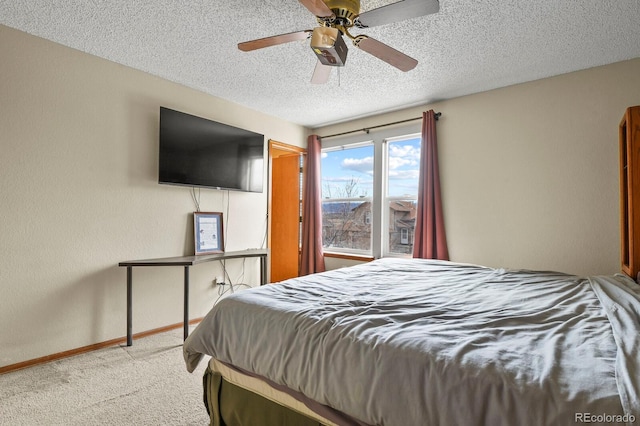 bedroom featuring a textured ceiling, carpet floors, baseboards, ceiling fan, and a textured wall