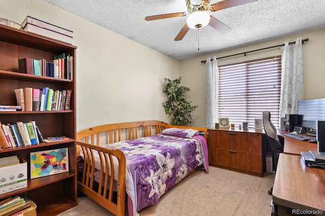 carpeted bedroom with a textured ceiling and a ceiling fan