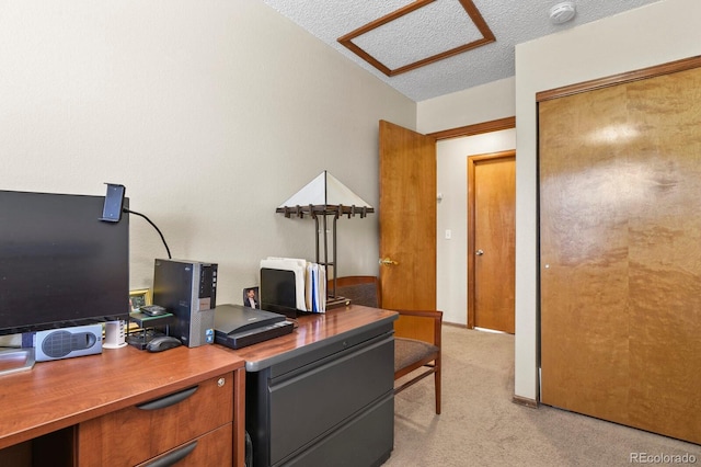 office area with light carpet, a textured ceiling, and attic access