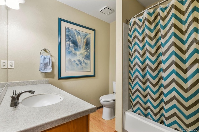 full bathroom with visible vents, shower / bath combo with shower curtain, toilet, wood finished floors, and vanity